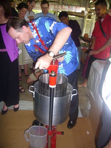 John Key pressing organic virgin coconut oil in Savaii.