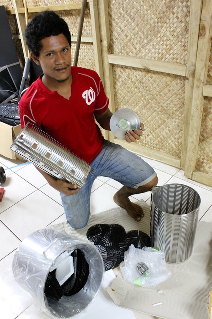 Women in Business Development worker Telea Atonio with the pressing equipment donated by the Asia-Pacific Ladies Friendship Society of Japan and Samoa Embassy staff.